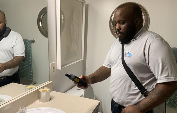 Rodney Ruffin, certified home inspector, inspecting the sink in a bathroom.